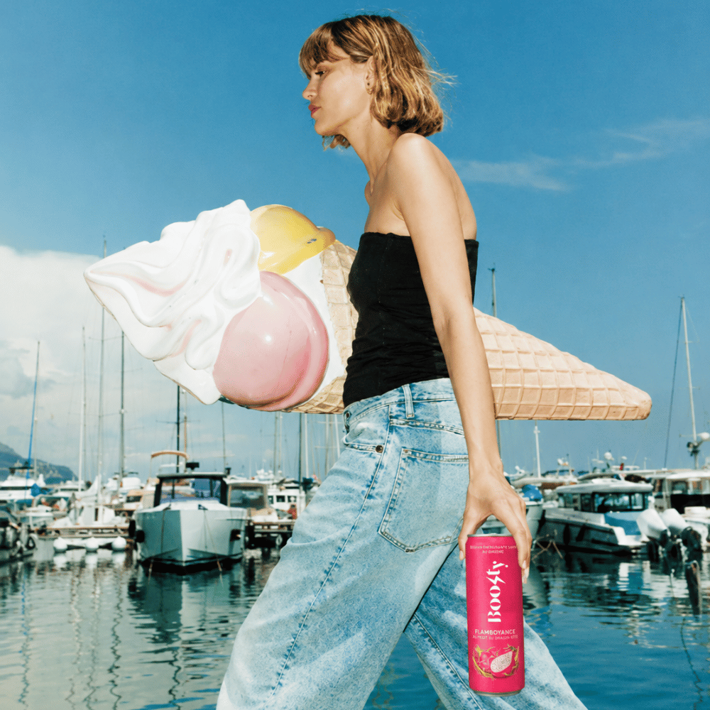Femme qui marche avec une canette Boosty dans la main